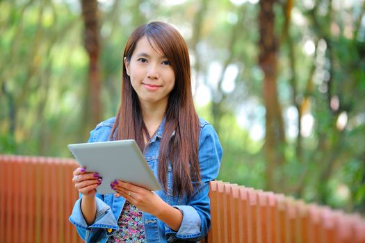 young asian woman with tablet computer outdoor