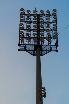 high-powered stadium floodlights seen against a pretty sky