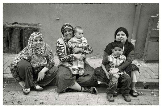 TURKISH MOTHER AND SONS, ISTANBUL, TURKEY, APRIL 17, 2012: Turkish girls in the street with their sons asking for being photographed - Istanbul, Turkey.