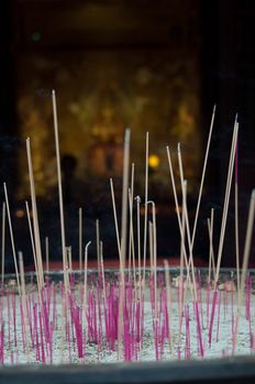 Incense sticks burning in pot outside Buddhist Temple