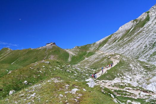 summer landscpe of Dolomites with a group of  hikers in action