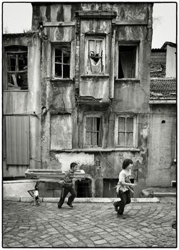 ACTIVE TYRKISH BOYS, ISTANBUL, TURKEY, APRIL 17, 2012: Kids playing around with their dog in the streets of Fatih, Istanbul, Turkey.