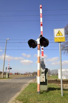 The picture shows an open level crossing on the road by the railway track.