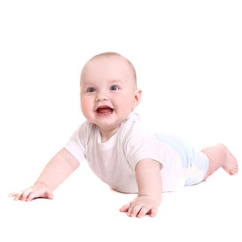 the little boy lies on a stomach and smiles. it is isolated on a white background.