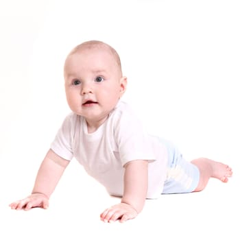 the little boy lies on a stomach. it is isolated on a white background.