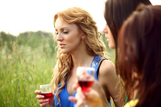 girls drink wine on nature background