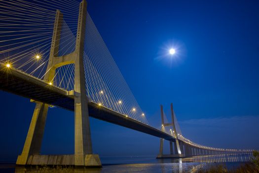Long Vasco da Gama bridge at night under moonlight