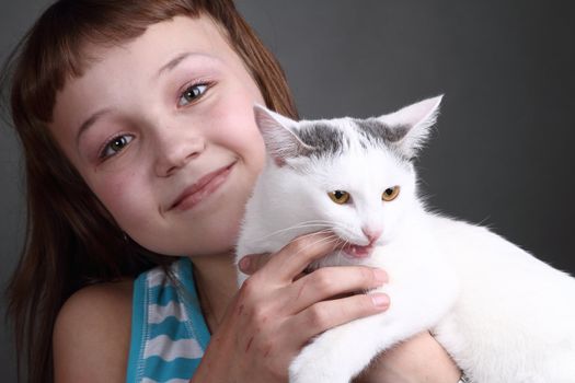 the girl and white cat play. close up