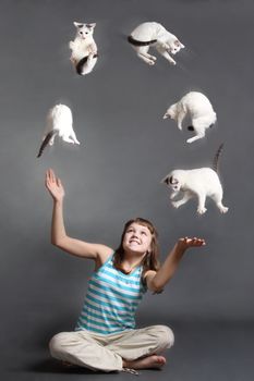 the girl with scratch on a cheek juggles with white cats
