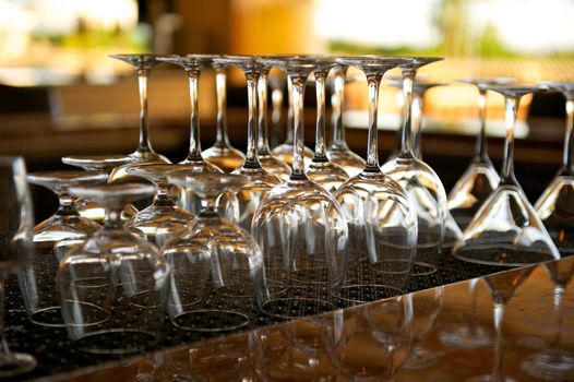 Clear glass goblets and martini glasses organized and placed on a bar