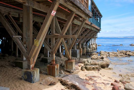 The foundation and supports of a large wooden pier along the coast in Monterey California