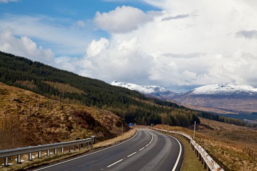 Empty Countryside Road Highway of Highlands Scotland with Beautiful Snow Mountain Range