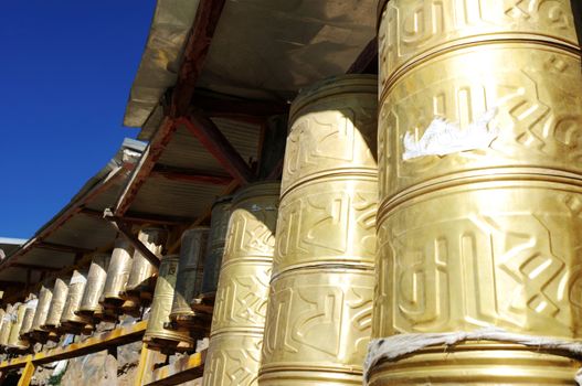 Golden prayer wheels in a historic Tibetan lamasery