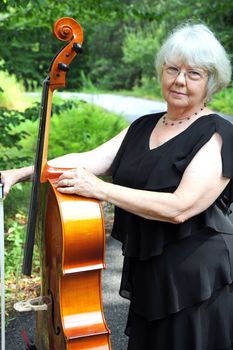Female cellist with her cello outside.