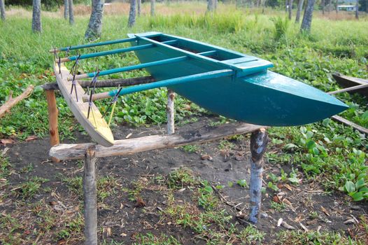 Green timber canoe at sea coast, Papua New Guinea