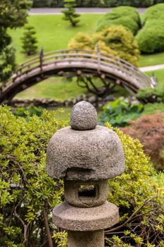 Japanese garden with ornamental stone garden lantern and bridge