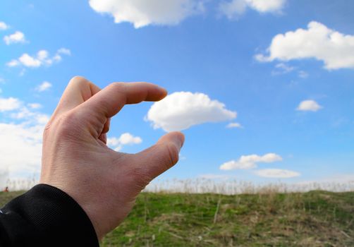 Human hand reaching for a cloud and grabing it
