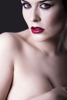 Sensual beautiful nude brunette girl over dark backdrop, caucasian woman