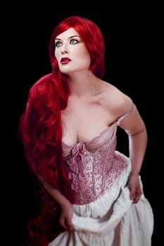 Red haired woman in lingerie over black background