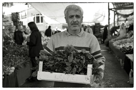 GREENGROCER EYUP MARKET, Istanbul, APRIL 13, 2012: Greengrocer on the friday market of Eyup, Istanbul Turkey with a box of Kuzu.