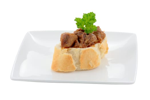 appetizer dish typical of the spanish cuisine of pork on slice of bread cut off and isolated