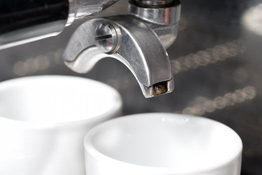 Portafilter and coffee machine. Focus on nearest spout.