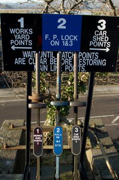 A vintage set of points levers for railway use with signs indicating their use.