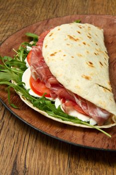 italian piadina with ham, fresh salad and mozzarella cheese