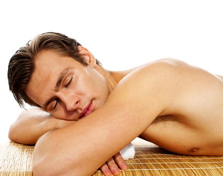 Young man enjoying the treatment in spa salon on white background