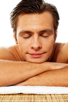 Attractive man resting with closed eyes at spa. Front view, closeup