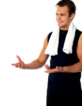 Male trainer posing with open hands and looking away. Studio shot