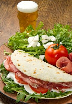 italian piadina with ham, fresh salad and mozzarella cheese