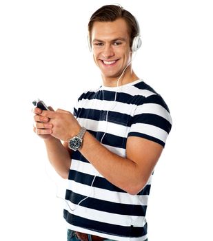 Handsome man enjoying music through headphones facing camera