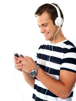 Male teenager with mp3 player and earbuds listen to music. Surfing playlist