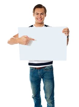 Portrait of young man pointing at blank signboard. Isolated on white