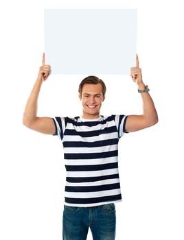 Confident young man showing blank billborad over his head