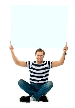 Seated man showing blank signboard against white background