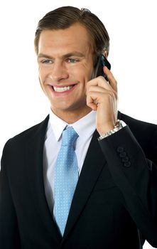 Young businessman talking on mobile phone looking away and smiling