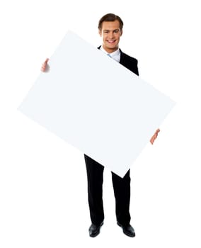 Young corporate male holding tilted blank billboard isolated against white background