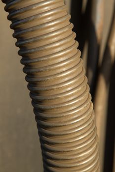 A flexible engineering hose pipe sprayed in gold paint.