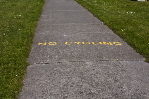 A no cycling notice painted on a footpath