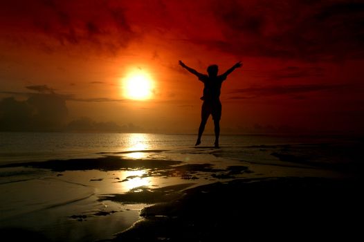 silhouette of a man jumping toward sunrise photographed by adding a filter gradation                              