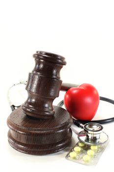 judges gavel with stethoscope and pills