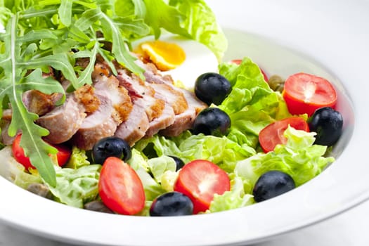 vegetable salad with fried duck breast slices and egg