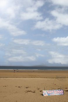 sandy beach with children getting ready to be taught surfing in ballybunion county Kerry Ireland in black and white