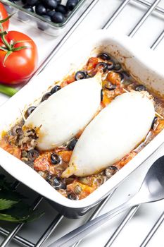 baked sepia with tomatoes and black olives filled with pearl barley risotto