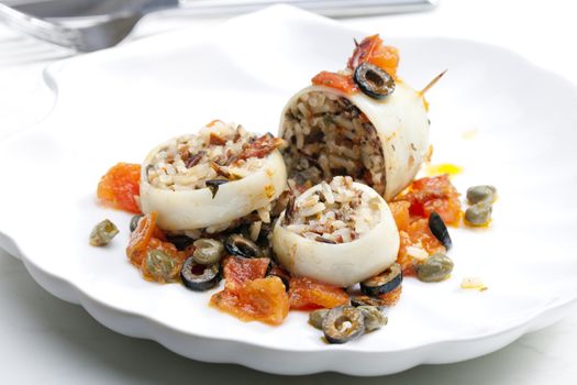 baked sepia with tomatoes and black olives filled with pearl barley risotto