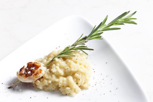 grilled Saint Jacques mollusc on rosemary needle with risotto