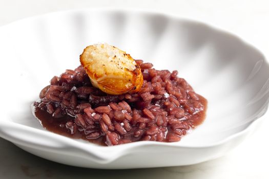 fried Saint Jacques mollusc on risotto steamed with red wine