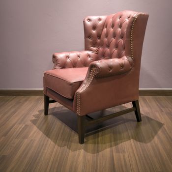 Side of Classic Chesterfield luxury Brown Leather armchair on Wood floor